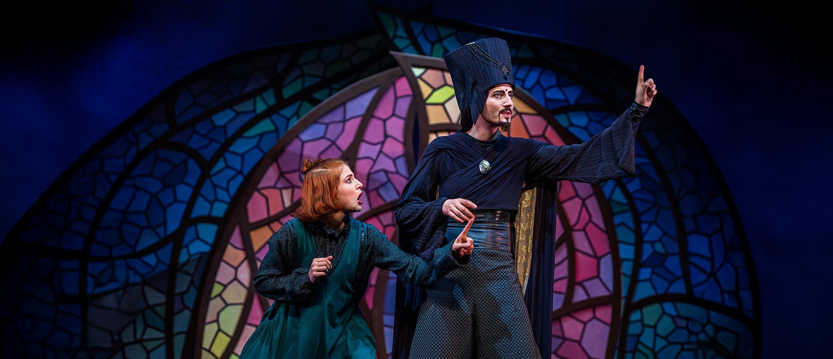 Szenenbild aus „Aladin – das Musical“ von Theater Liberi Zwei Darsteller auf der Bühne in einer spannenden Szene aus „Aladin – das Musical“ mit bunter Kulisse im Hintergrund