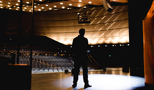 Soundcheck und Bühnenlicht bei Theater Liberi Silhouette eines Darstellers bei der Bühnenprobe im leeren Zuschauerraum – die Bühne ist in stimmungsvolles Licht getaucht.